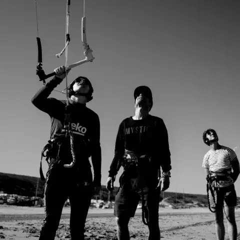 Kitesurfeurs en plein briefing sur la plage