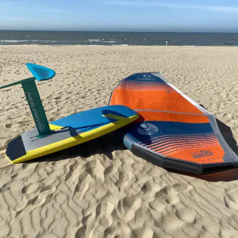 Wing et foil posés sur le sable