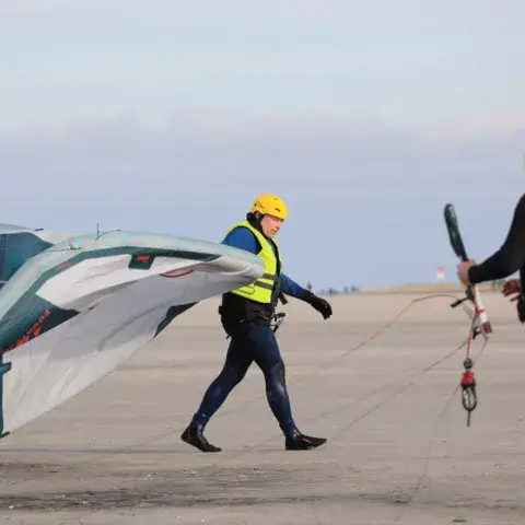 Moniteur et élève avec un kite sur la plage