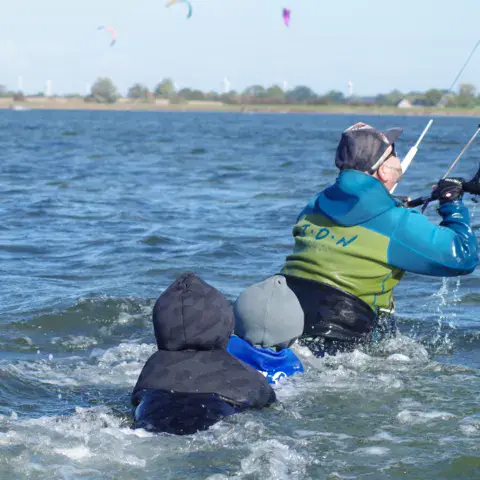 Un moniteur accompagne un élève dans l'eau
