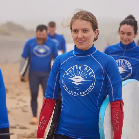 Groupe d'élèves en haut bleu de l'école sur la plage