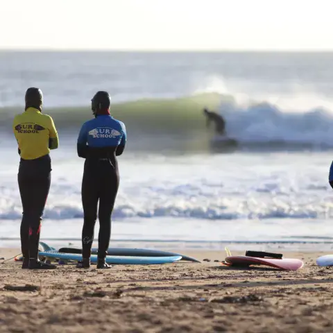 Moniteurs observant les vagues depuis la plage