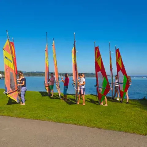 Groupe de débutants avec les voiles sur la rive