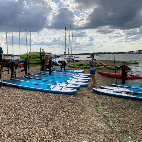 Groupe sur la plage avec des paddles avant la sortie