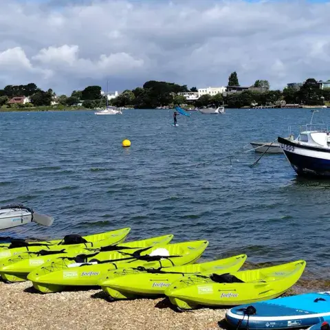 Kayaks alignés sur la plage au bord du plan d'eau