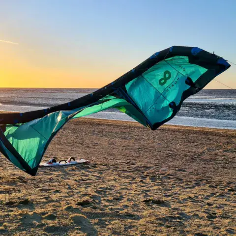 Kite déployé sur la plage au coucher du soleil