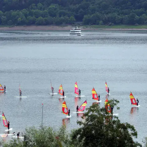 Groupe de windsurfeurs sur le lac