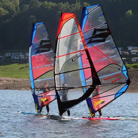 Trois windsurfeurs côte à côte