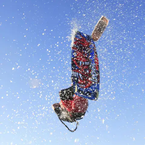 Kitesurfeur en saut, planche au-dessus de l'eau