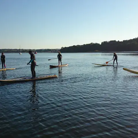 Groupe de paddleurs sur une eau calme