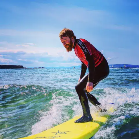Surfeur sur une planche jaune dans les vagues
