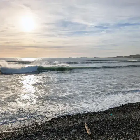Vagues et plage de galets de Newgale au soleil couchant