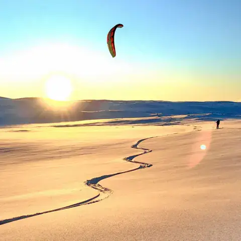 Aile de snowkite au coucher du soleil