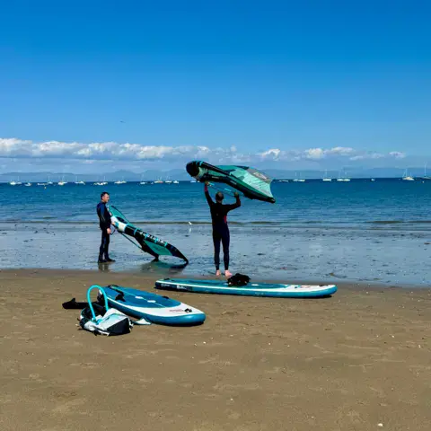 Ailes et planches de wing foil sur la plage avant un cours