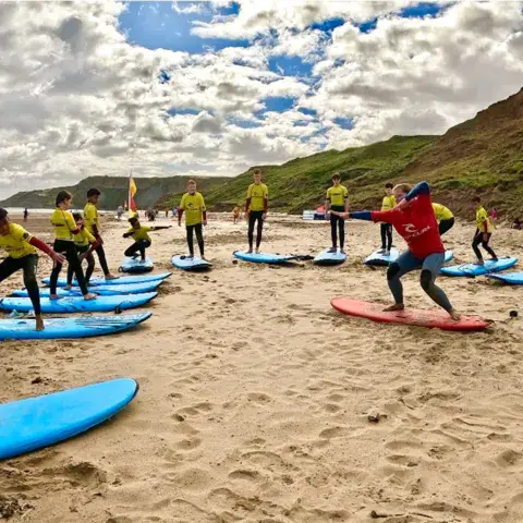 Groupe en cours de surf sur la plage, planches alignées