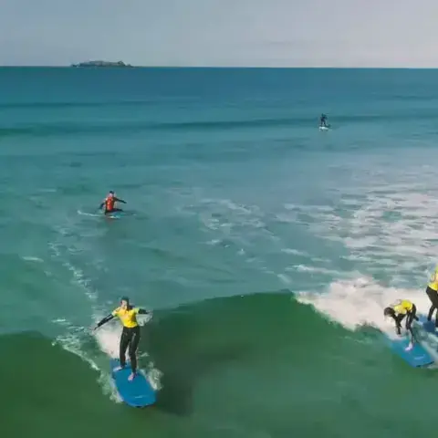 Cours de surf collectif dans les vagues de la baie