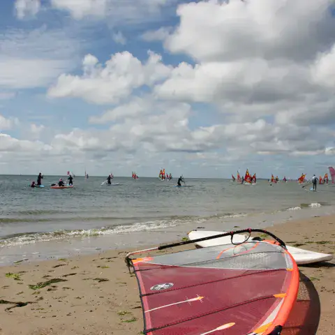 Windsurfeurs sur l'eau, planche au premier plan