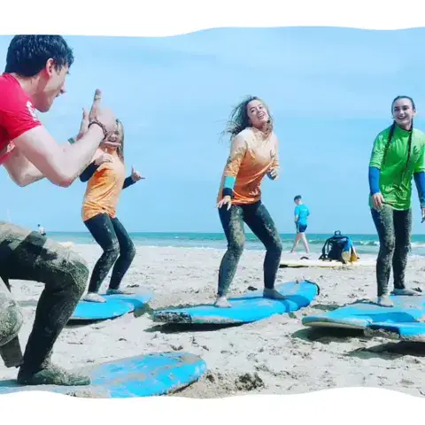 Échauffement d'un groupe sur la plage avant le cours de surf