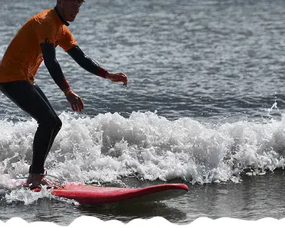 Surfeur debout sur sa planche dans les vagues