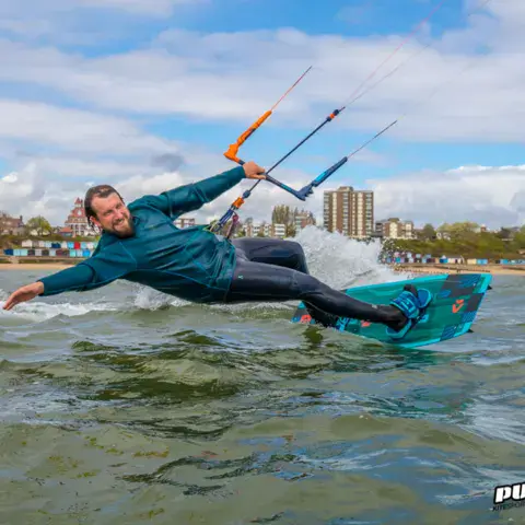 Kitesurfeur devant les cabines de plage de la côte