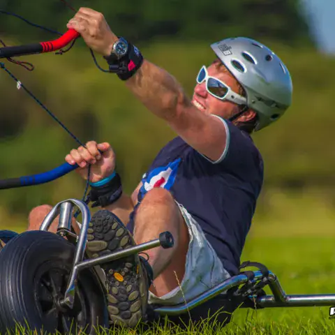 Pilote de kite buggy sur l'herbe