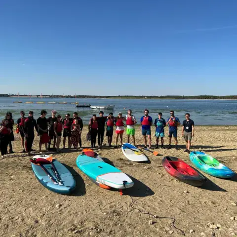 Groupe et planches de paddle alignées sur la plage