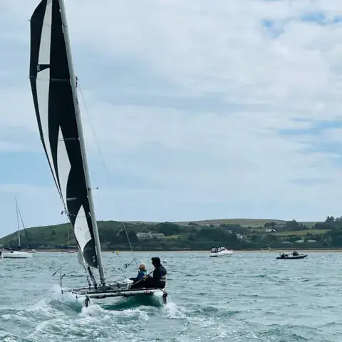 Un catamaran à voile noire au large d'Abersoch