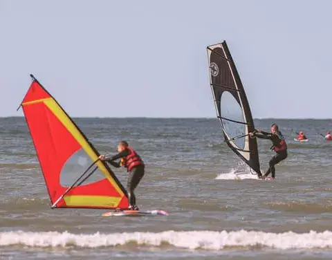 Deux planches à voile dans les vagues