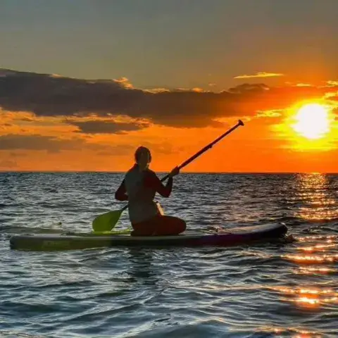 Pagayeur sur un paddle au coucher du soleil