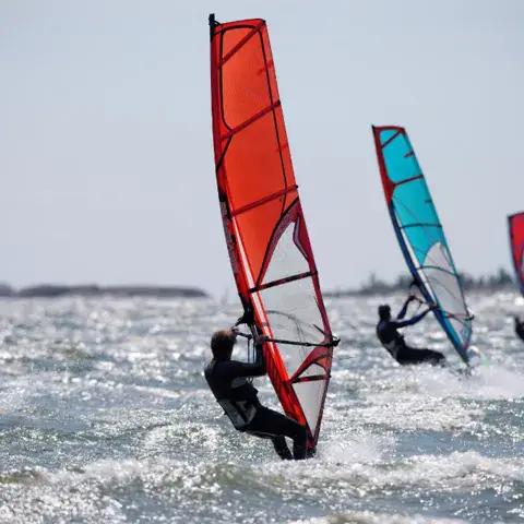 Trois planches à voile en navigation