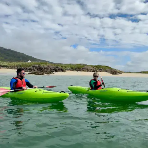 Deux kayakistes près d'une plage de sable du Connemara