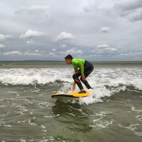 Surfeuse prenant une vague en cours
