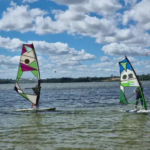 Deux élèves de windsurf sur l'eau peu profonde