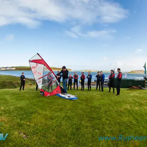 Initiation au gréement d'une planche à voile sur la pelouse