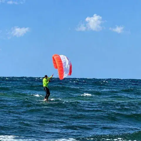 Kitesurfeur sur la mer, aile rouge et blanche