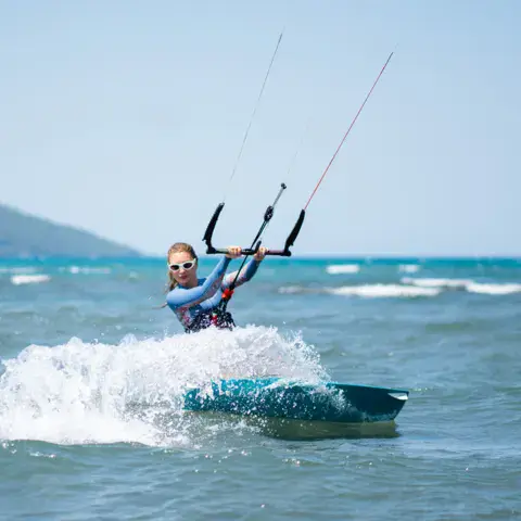 Kitesurfeuse sur l'eau, le vent de côté