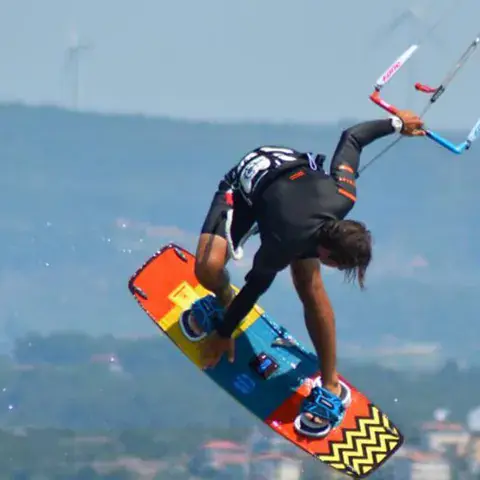 Kitesurfeur en saut avec la côte en arrière-plan