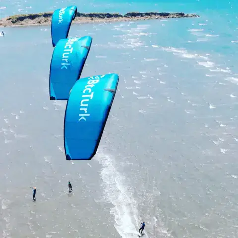 Vue aérienne de kitesurfeurs sur l'eau peu profonde