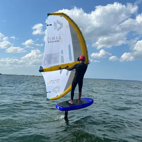 Pratiquant de wing foil au-dessus de l'eau