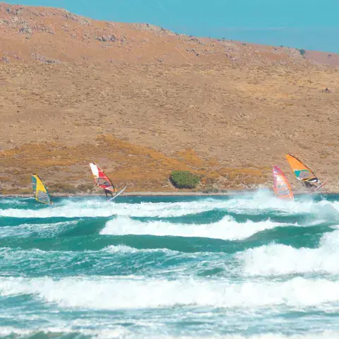 Planches à voile dans les vagues devant la côte