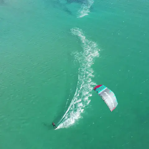 Vue aérienne d'un kitesurfeur sur l'eau turquoise
