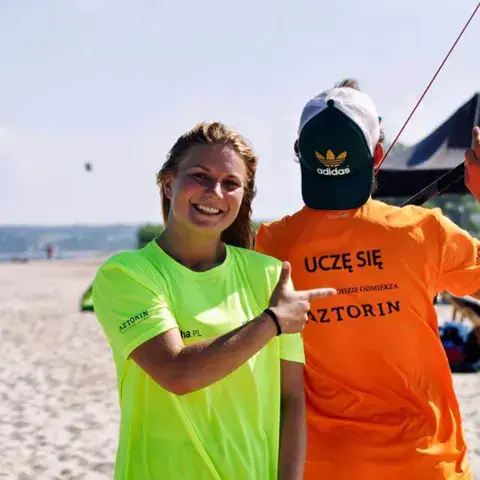 Moniteur et élève sur la plage de Rewa, avec des ailes de kite en arrière-plan
