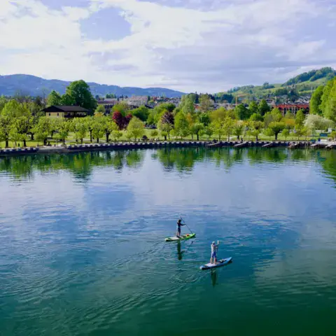 Deux pagayeurs sur le lac, devant la rive de Mondsee