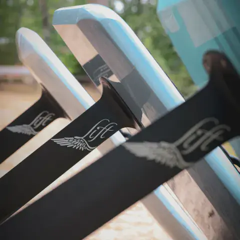 Planches d'e-foil alignées sur la plage