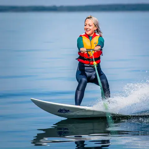 Élève tractée derrière le bateau par temps calme