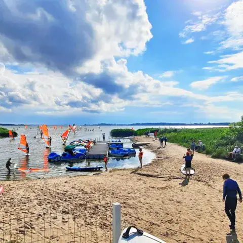 Plage de mise à l'eau devant l'école, avec planches au bord