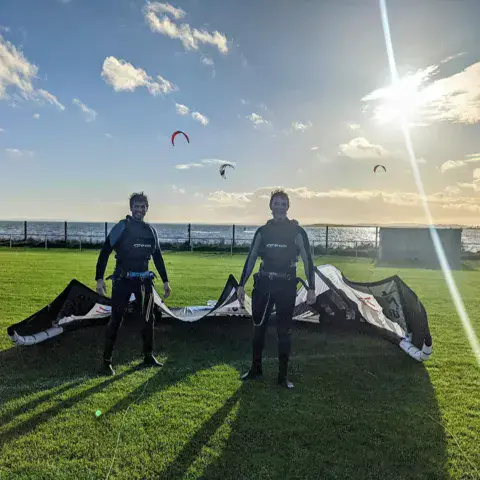 Un kitesurfeur dans les vagues près d'une côte rocheuse