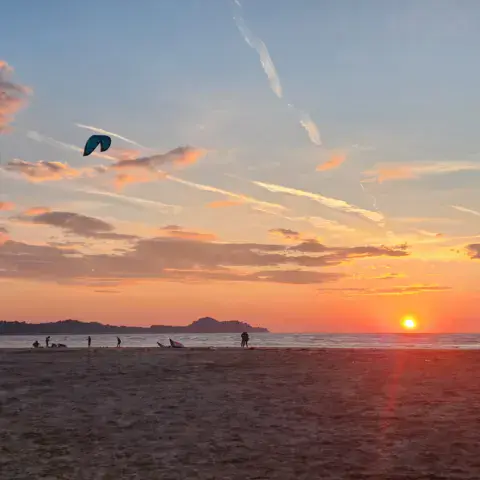 Coucher de soleil sur la plage, avec des ailes dans le ciel