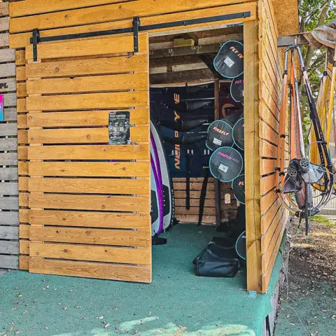 Cabane en bois de l'EASY Test Center avec voiles de windsurf