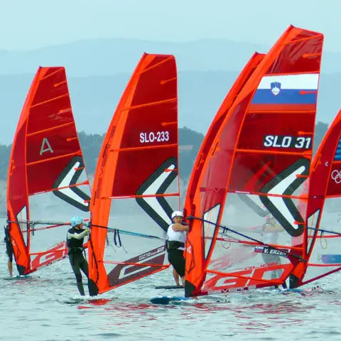 Quatre planches à voile rouges au départ d'une régate